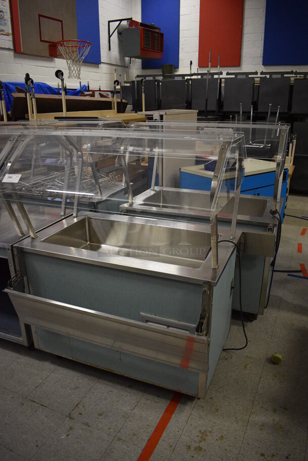 2 Vollrath Model 37045-2494-ANA Metal Commercial Serving Stations w/ Sneeze Guard and Tray Slide on Commercial Casters. 120 Volts, 1 Phase. 46x36x57.5. 2 Times Your Bid! (Clearview Elementary - Gym)