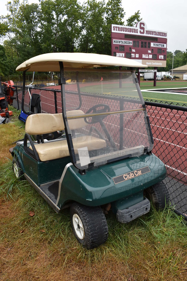 Green Electric Powered Golf Cart w/ Battery Charger. Needs New Battery. Comes w/ 1 Key. BUYER MUST REMOVE. 42x101x67.5. (stadium)
