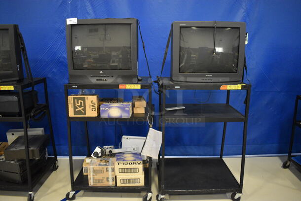 2 Black Metal AV Carts w/ Contents Including Zenith TV, Hitachi TV, Video Cassette Video Tapes. 32.5x27.5x48. 2 Times Your Bid! (Middle School Gym)