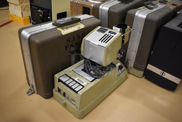 16 Various Tape Projectors in Hard Case Including Dukane. Includes 16x14x8. 16 Times Your Bid! (Chipperfield Elementary Gym)