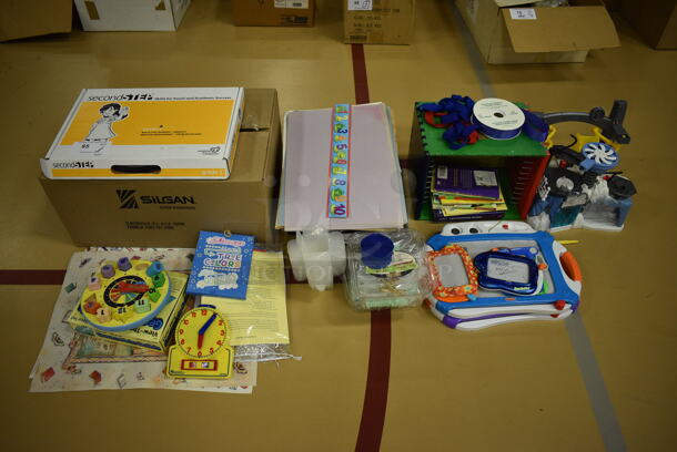 ALL ONE MONEY! Lot of Various Items Including Toys, Learning Clocks and Flashcards. (Chipperfield Elementary Gym)