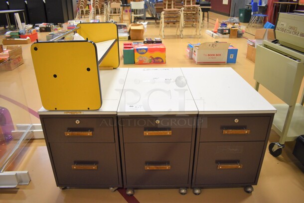 3 Portable 2 Drawer Filing Cabinets on Casters. 1 Has Attached Shelf. 15.5x28.5x21.5. 3 Times Your Bid! (Chipperfield Elementary Gym)