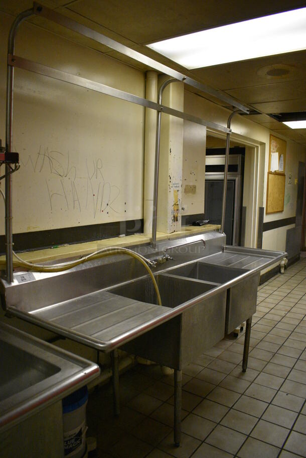 Stainless Steel Commercial 2 Bay Sink w/ Dual Drain Boards, Faucet, Handles and Pot Rack. BUYER MUST REMOVE. 97x28x90. Bays 22x22x14. Drain Boards 24x24x2. (dishwasher area) - Image 1 of 7