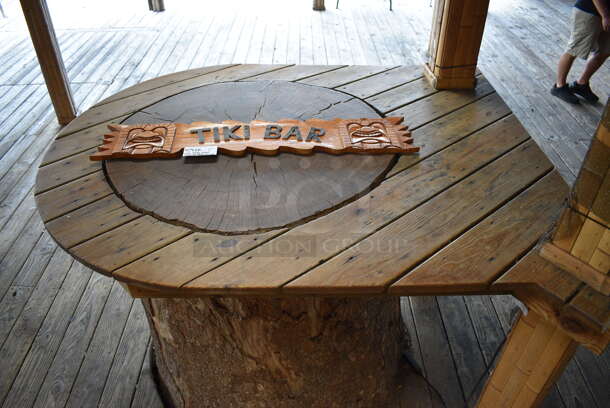 Wooden Tiki Bar Sign. Buyer Can Also Take Wooden Tabletop Around Stump If They Want To; That Is BUYER MUST REMOVE. 40x1x7.5, 50x63. (patio)