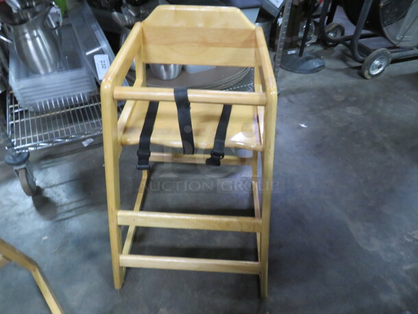 One Wooden High Chair With Safety Straps.