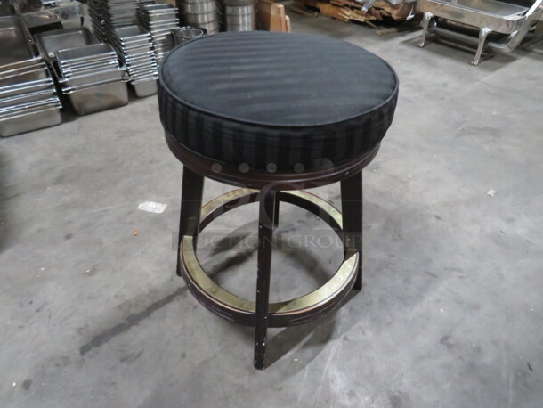 One Wooden Counter Height Bar Stool With Black Cushioned Swivel Seat And Footrest.
