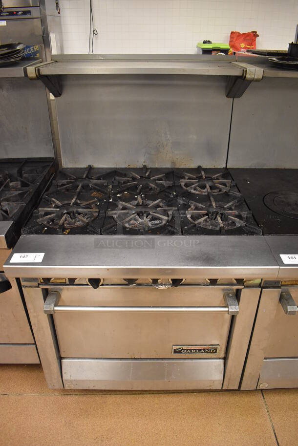 Garland M43R Stainless Steel Commercial Floor Style Natural Gas Powered 2 Burner Range w/ Flat Top, Oven, Over Shelf and Back Splash. BUYER MUST REMOVE. 34x38x58. Tested and Working! (Restaurant Kitchen) - Image 1 of 8