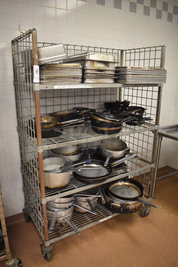 Metal 4 Tier Wire Shelving Unit w/ Contents Including Metal Baking Pans, Drop In Bins and Skillets on Commercial Casters. BUYER MUST DISMANTLE. PCI CANNOT DISMANTLE FOR SHIPPING. PLEASE CONSIDER FREIGHT CHARGES. 48x24x70. (Restaurant Kitchen)