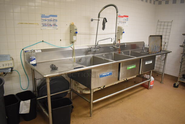 Stainless Steel Commercial 3 Bay Sink w/ Dual Drain Boards, 2 Faucets, 2 Handle Sets and Spray Nozzle Attachment. BUYER MUST REMOVE. 134x36x43. Bays 24x30x14. Drain Boards 28x32x2. (Education Kitchen 2)