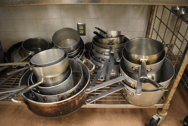 Metal 4 Tier Wire Shelving Unit on Commercial Casters w/ Contents Including Metal Bowls, Skillets and China Cap Strainers. BUYER MUST DISMANTLE. PCI CANNOT DISMANTLE FOR SHIPPING. PLEASE CONSIDER FREIGHT CHARGES. 60x24x78. (Education Kitchen 2) - Image 9 of 11
