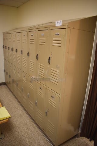Wall of 19 Tan Metal Lockers. BUYER MUST REMOVE. 132x18x71. (Womens Locker Room)