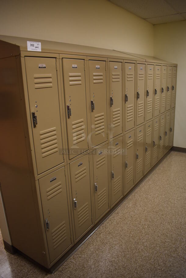 Wall of 22 Tan Metal Lockers. BUYER MUST REMOVE. 132x18x71. (Womens Locker Room)