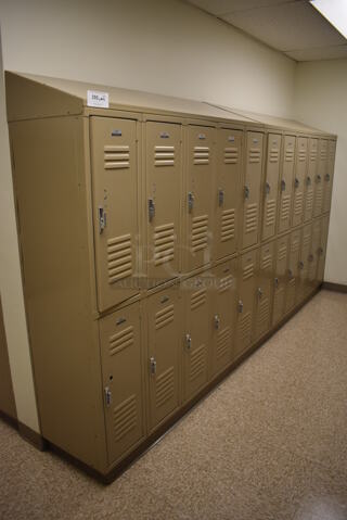 Wall of 22 Tan Metal Lockers. BUYER MUST REMOVE. 145x18x71. (Mens Locker Room)