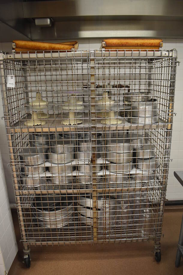 Chrome Finish 4 Tier Wire Shelving Unit w/ Liquor Cage on Commercial Casters. Comes w/ Contents Including 10 Metal Cake Stands and Various Metal Round Baking Pans. BUYER MUST DISMANTLE. PCI CANNOT DISMANTLE FOR SHIPPING. PLEASE CONSIDER FREIGHT CHARGES. 48x25x70. (Pastry Kitchen)