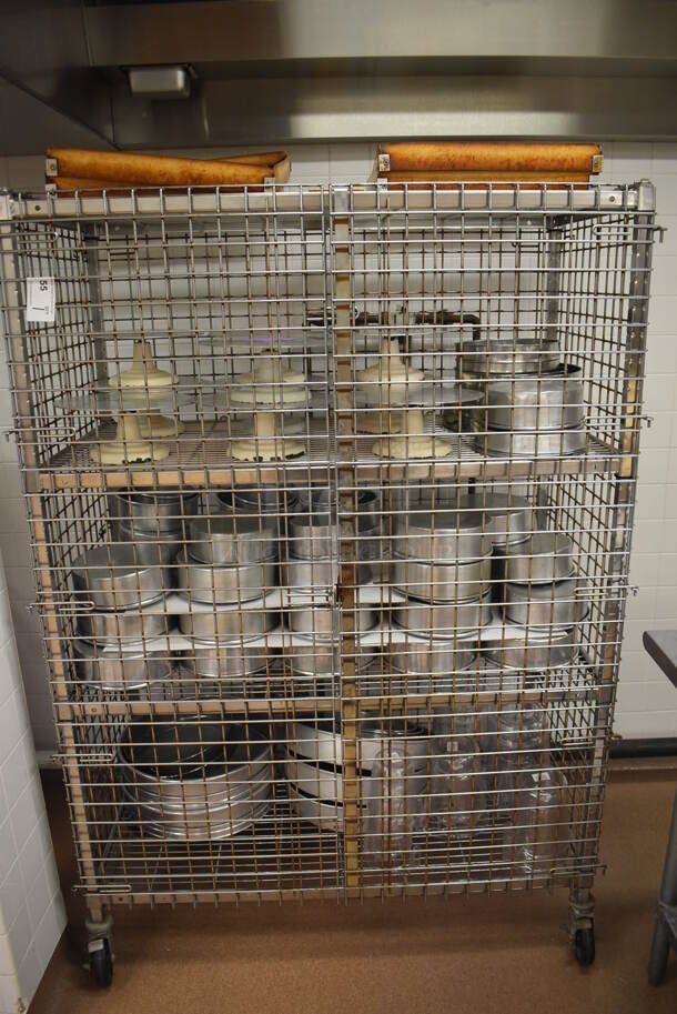Chrome Finish 4 Tier Wire Shelving Unit w/ Liquor Cage on Commercial Casters. Comes w/ Contents Including 10 Metal Cake Stands and Various Metal Round Baking Pans. BUYER MUST DISMANTLE. PCI CANNOT DISMANTLE FOR SHIPPING. PLEASE CONSIDER FREIGHT CHARGES. 48x25x70. (Pastry Kitchen) - Image 1 of 7