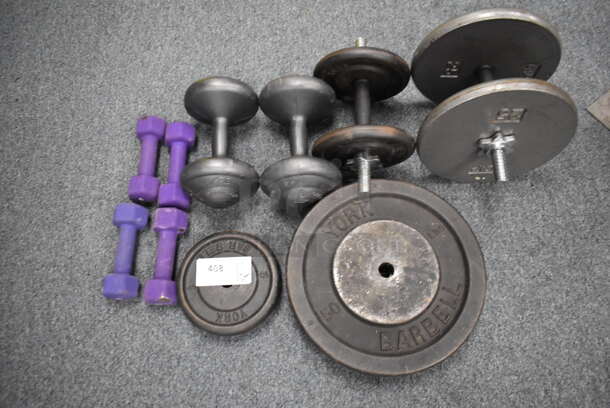 ALL ONE MONEY! Lot of 4 5 Pound Dumbbells, 10 Pound Weight Plate, 50 Pound Weight Plate, 2 10 Pound Dumbbells, 25 Pound Dumbbell. (Classroom 10)