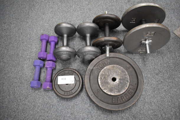 ALL ONE MONEY! Lot of 4 5 Pound Dumbbells, 10 Pound Weight Plate, 50 Pound Weight Plate, 2 10 Pound Dumbbells, 25 Pound Dumbbell. (Classroom 10) - Image 1 of 6