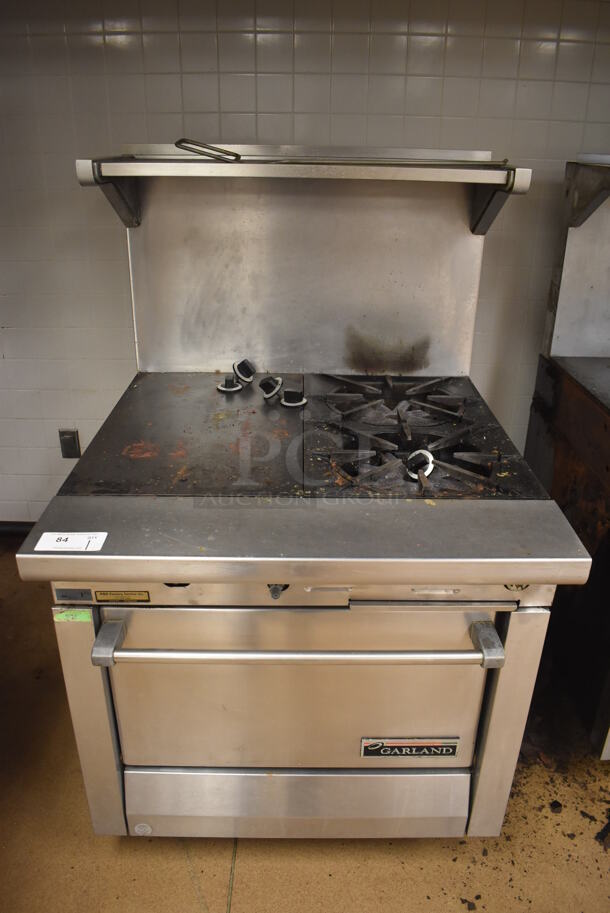 Garland M42-6R Stainless Steel Commercial Natural Gas Powered 2 Burner Range w/ Flat Top, Oven, Over Shelf and Back Splash. BUYER MUST REMOVE. 34x38x58. Tested and Working! (Education Kitchen)