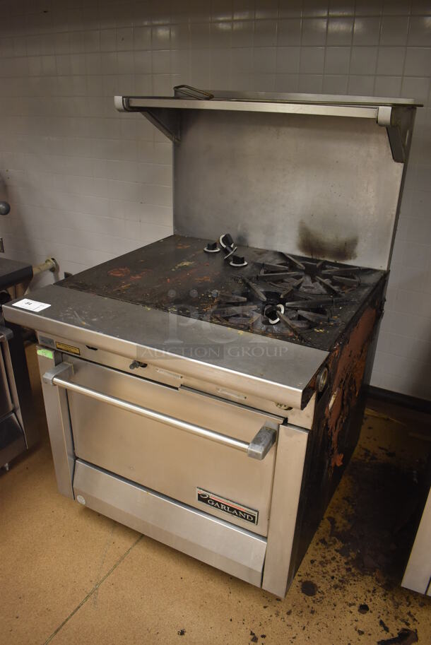 Garland M42-6R Stainless Steel Commercial Natural Gas Powered 2 Burner Range w/ Flat Top, Oven, Over Shelf and Back Splash. BUYER MUST REMOVE. 34x38x58. Tested and Working! (Education Kitchen) - Image 3 of 8