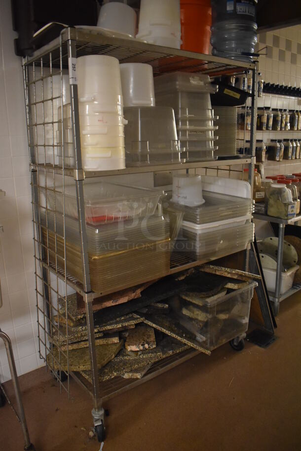 Metal 4 Tier Wire Shelving Unit on Commercial Casters w/ Contents Including Poly Bins and Marble Pieces. BUYER MUST DISMANTLE. PCI CANNOT DISMANTLE FOR SHIPPING. PLEASE CONSIDER FREIGHT CHARGES. 48x24x78. (Dishroom)