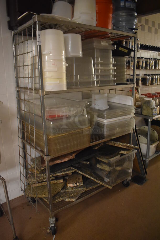 Metal 4 Tier Wire Shelving Unit on Commercial Casters w/ Contents Including Poly Bins and Marble Pieces. BUYER MUST DISMANTLE. PCI CANNOT DISMANTLE FOR SHIPPING. PLEASE CONSIDER FREIGHT CHARGES. 48x24x78. (Dishroom) - Image 1 of 7