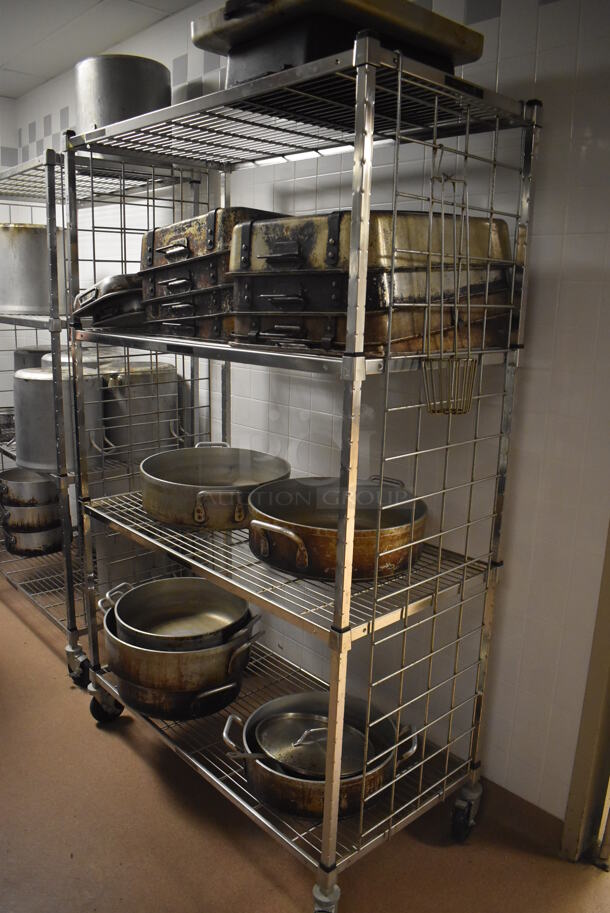 Metal 4 Tier Wire Shelving Unit on Commercial Casters w/ Contents Including Metal Stock Pots and Baking Pans. BUYER MUST DISMANTLE. PCI CANNOT DISMANTLE FOR SHIPPING. PLEASE CONSIDER FREIGHT CHARGES. 48x24x78. (Dishroom)