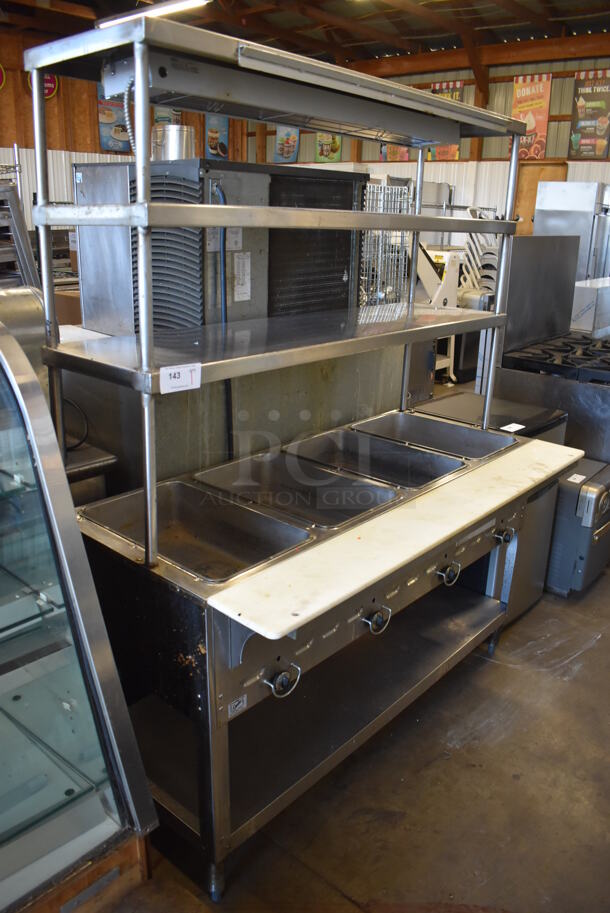 Duke Stainless Steel Commercial 4 Well Steam Table w/ 2 Over Shelves, Warming Strip, Cutting Board and Under Shelf. 58x31x74. Cannot Test Due To Missing Power Cord