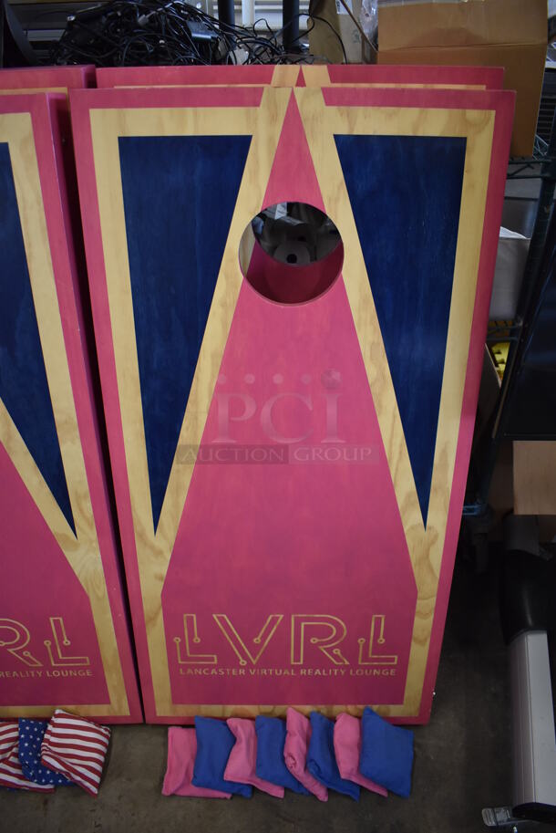2 Wooden Pink and Blue LVRL Corn Hole Boards w/ 2 Pink Wooden Burky Boards, 4 Pink Bean Bags and 4 Blue Bean Bags. 24x48x4, 23x23x39, 23x23x63. 2 Times Your Bid!