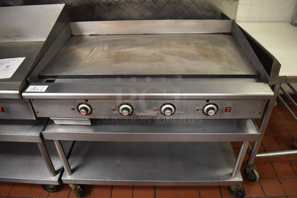 Vulcan Stainless Steel Commercial Countertop Natural Gas Powered Flat Top Griddle on Stainless Steel Equipment Stand w/ Under Shelf and Commercial Casters. Unit Was In Working Condition When Restaurant Closed. BUYER MUST REMOVE. (Front Kitchen)