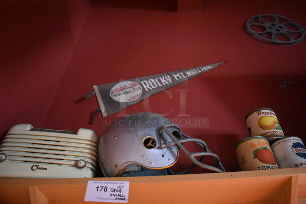 ALL ONE MONEY! Shelf Lot of Various Items Including Bottles and Helmet and Wall Decor Above The Shelf. Does Not Include The Shelf Itself or The Television. BUYER MUST REMOVE. (Dining Room) - Image 4 of 4