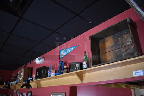 ALL ONE MONEY! Shelf Lot of Various Items Including Crates, Bottles and Luggage and Wall Decor Above The Shelf. Does Not Include The Shelf Itself. BUYER MUST REMOVE. (Party Dining Room)