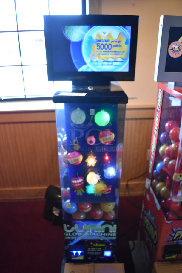 Lumini Metal Commercial Floor Style Glow Toy Vending Machine w/ Cash Acceptor. Comes w/ Box of Extra Toys. 110 Volts, 1 Phase. Unit Was In Working Condition When Restaurant Closed. BUYER MUST REMOVE. (Dining Room)
