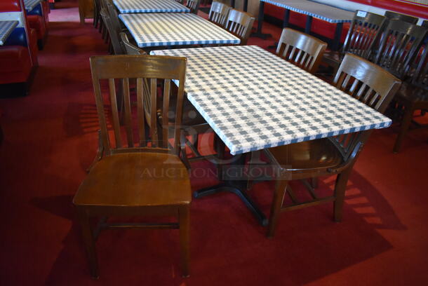 Table w/ Table Cloth on Black Metal Table Base and 4 Wooden Dining Chairs. Stock Picture - Cosmetic Condition May Vary. 48x48x30, 18x16x36. (Dining Room)