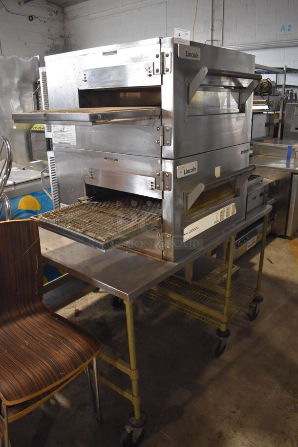 2 2014 Lincoln Impinger 1132-008-U-KF004 Stainless Steel Commercial Electric Powered Conveyor Pizza Oven on Stainless Steel Table w/ Commercial Casters. 208 Volts, 3 Phase. 55x44x69. 2 Times Your Bid!