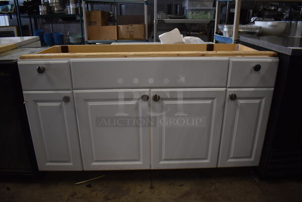 White Bathroom Vanity Without Top And Appearance of 6 Cabinets With 6 Silver Knobs. 
