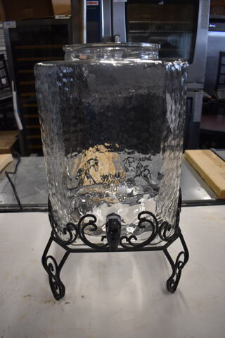 Large Textured Glass Beverage Dispenser Without Top on Black Decorative Stand.