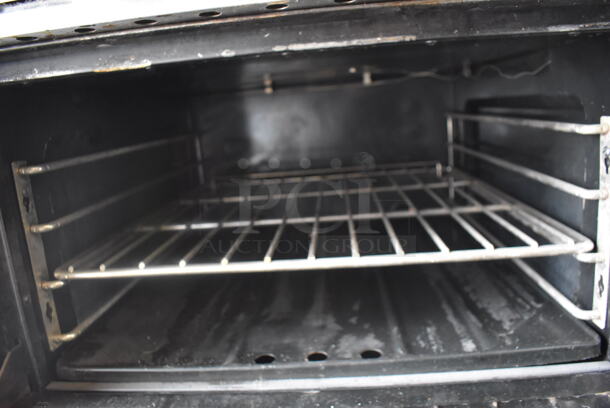 Garland Natural Gas Powered Commercial Stainless Steel Oven With Steel Racks And Top Griddle With Overshelf On Galvanized Legs.  - Image 5 of 7