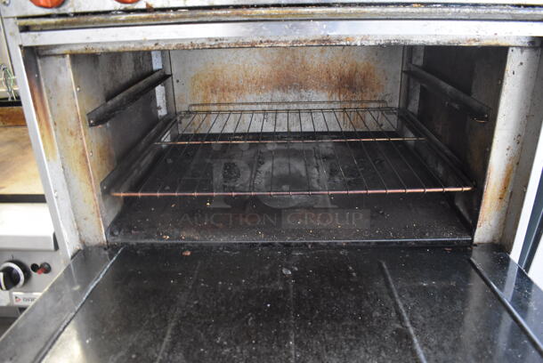 Bakers Pride Commercial Stainless Steel 6 Burner Natural Gas Powered Range With Standard Oven With  Steel Racks and Salamander Broiler On Commercial Casters.  - Image 7 of 8