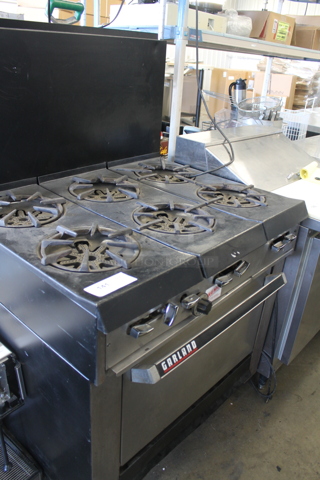 Garland Commercial Stainless Steel Natural Gas Powered Stove With 6 Burners, Backsplash And Oven With Steel Rack.