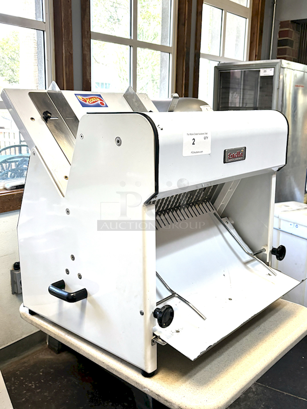 LIKE NEW! Estella Countertop Bread Slicer - 3/4" Slice Thickness, 18 3/4" Max Loaf Length - 110V. Stainless Steel Construction, Yield 240 Slicers Per Hour, Fits bread loaf sizes up to 6" x 18 3/4" Includes Manual. 26.6" X 24.8 " X 29.1" - Image 1 of 6