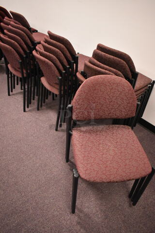 23 Stackable Maroon Patterned Chairs on Black Metal Legs. 23 Times Your Bid! BUYER MUST REMOVE: Bring Tools and Manpower Needed To Remove This Item. (back room)
