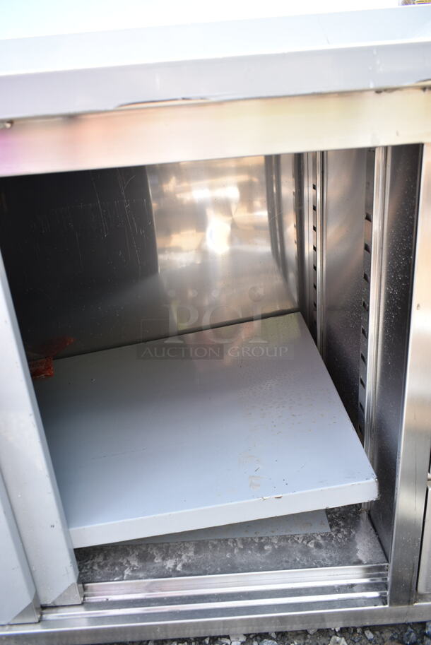 BRAND NEW SCRATCH AND DENT! Regency 600EBTB3060R 30" x 60" 16 Gauge Type 304 Stainless Steel Enclosed Base Sliding Door Table with Drawers and 6" Backsplash - Image 4 of 6