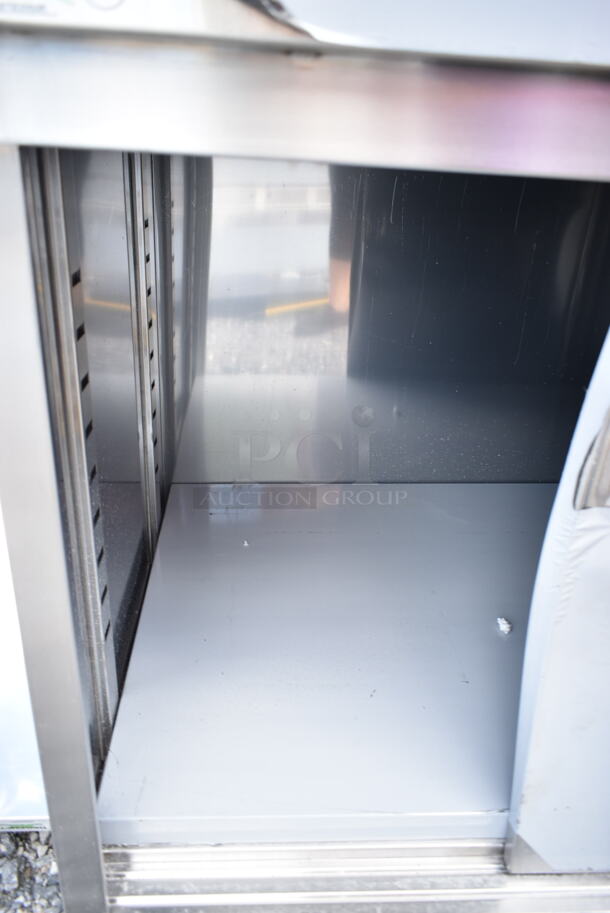 BRAND NEW SCRATCH AND DENT! Regency 600EBTB3060R 30" x 60" 16 Gauge Type 304 Stainless Steel Enclosed Base Sliding Door Table with Drawers and 6" Backsplash - Image 4 of 7