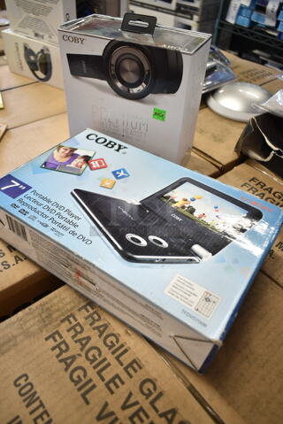 2 BRAND NEW IN BOX! Items Including Coby Portable DVD Player and Coby Premium wireless Headset. 2 Times Your Bid!