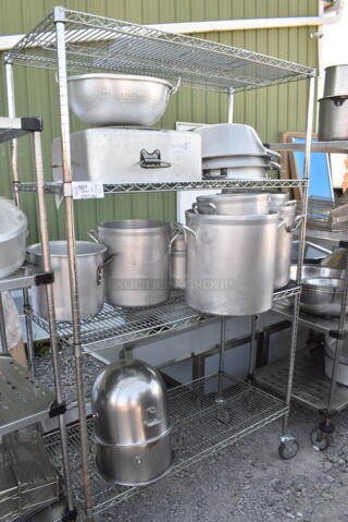 Chrome Finish 4 Tier Wire Shelving Unit on Commercial Casters w/ Contents Including Metal Stock Pots and 2 Mixing Bowls. BUYER MUST DISMANTLE. PCI CANNOT DISMANTLE FOR SHIPPING. PLEASE CONSIDER FREIGHT CHARGES.