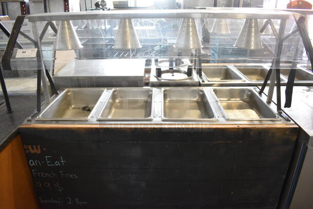 Vollrath Model 3871060 Stainless Steel Commercial 4 Well Steam Table w/ 4 Lamps and Sneeze Guard. 120 Volts, 1 Phase. 60x29x58. Cannot Test Due To Plug Style