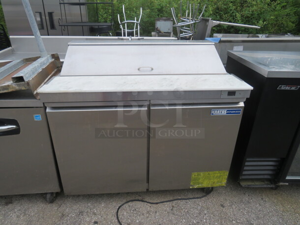 One Kratos 2 Door Prep Table With 2 Racks, And Cutting Board On Casters. Model# 69K-770HC. 115 Volt. 48X33X45.5 - Image 1 of 2