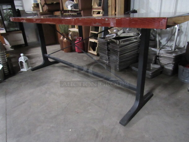 One Bar Height Wooden Table With Heavy Laquered Top, And An Industrial Looking Metal Base. 110X32X41