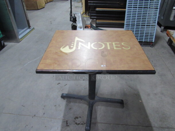 One Beige Table Top  With The NOTES Logo, On A Pedestal Base. 30X24X30