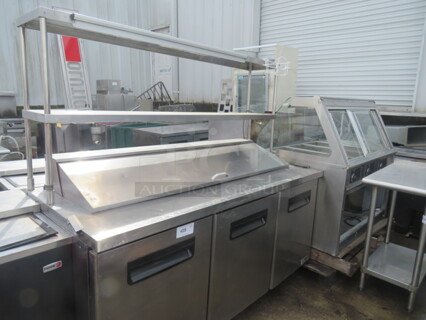 One Blue Air 3 Door Refrigerated Prep Table With 2 SS Over SHelves, 48 Inch Ticket Rail, 10 Inch Wire Basket, And 3 Racks, On Casters. Model# BAPT72. 115 Volt. 72X30X68